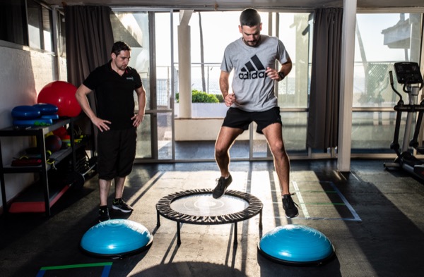 Paciente en sesión de reeducación funcional guiada con análisis de patrón de movimiento