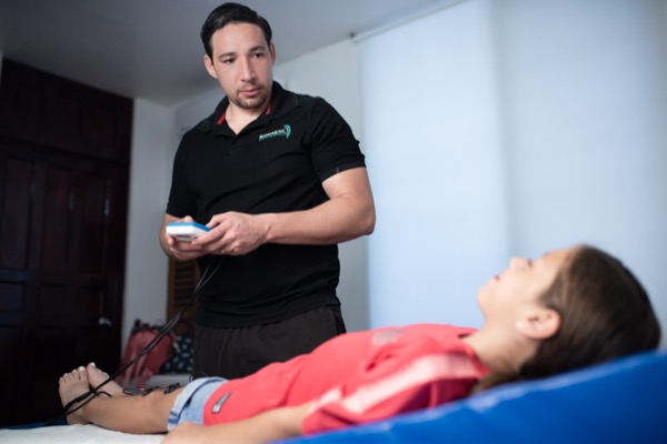 Médico traumatólogo en consulta especializada interpretando estudios de imagen y prescribiendo tratamiento